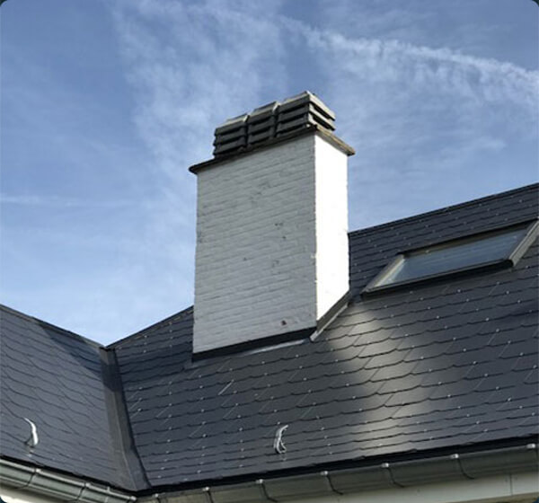 Réalisation de toitures ardoise noire ciel bleu cheminée briques peinture blanche